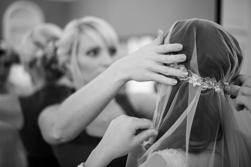 Bridebook.co.uk bride putting on cap veil
