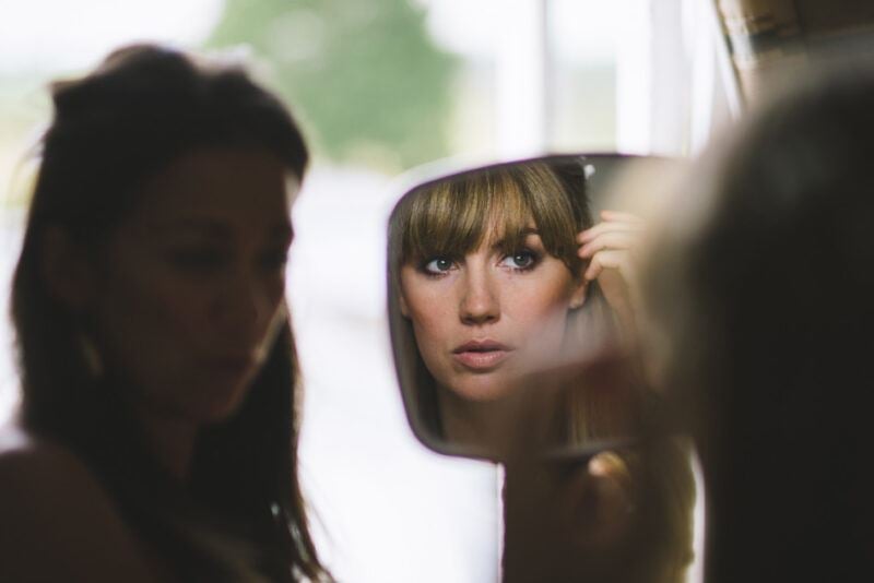 www.bridebook.co.uk bride checking her make up in the mirror