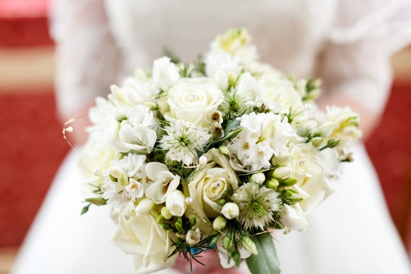 a bride holding a white bouquet waist height close up shot 