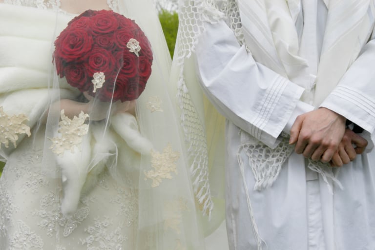 Traditional Jewish wedding couple wearing white