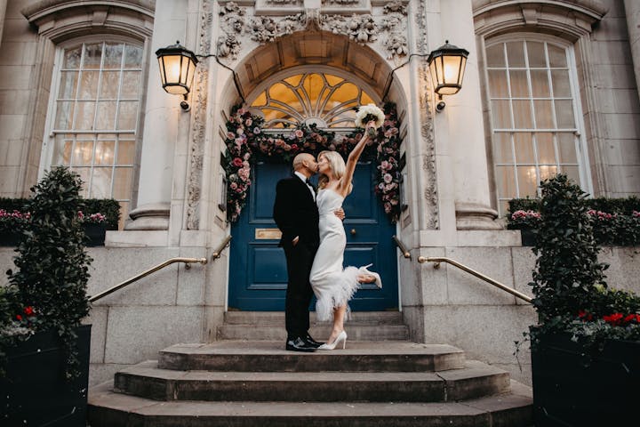 Couple kissing on the steps of a registry office wedding