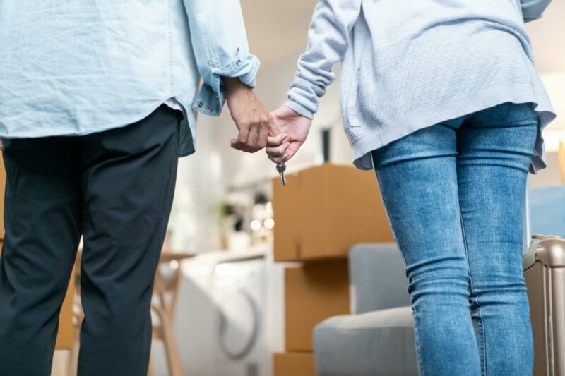 Homeowners holding hands with a key