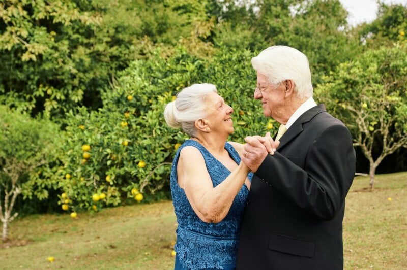 Couple d'un âge en train de danser dans un jardin