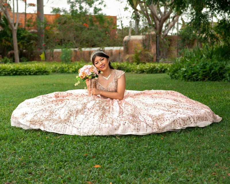Une femme en robe volumineuse rose et dorée, coiffée d’un diadème, pose avec un bouquet de fleurs, évoquant un mariage féerique en plein air.  Ces descriptions sont optimisées pour l’accessibilité et le SEO tout en étant précises et évocatrices.