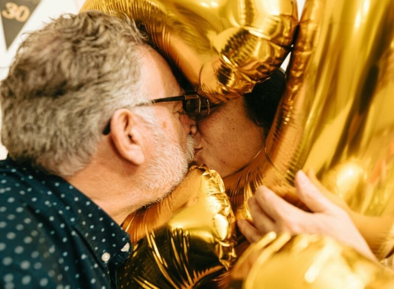 Couple s'embrassant derrière un ballon doré