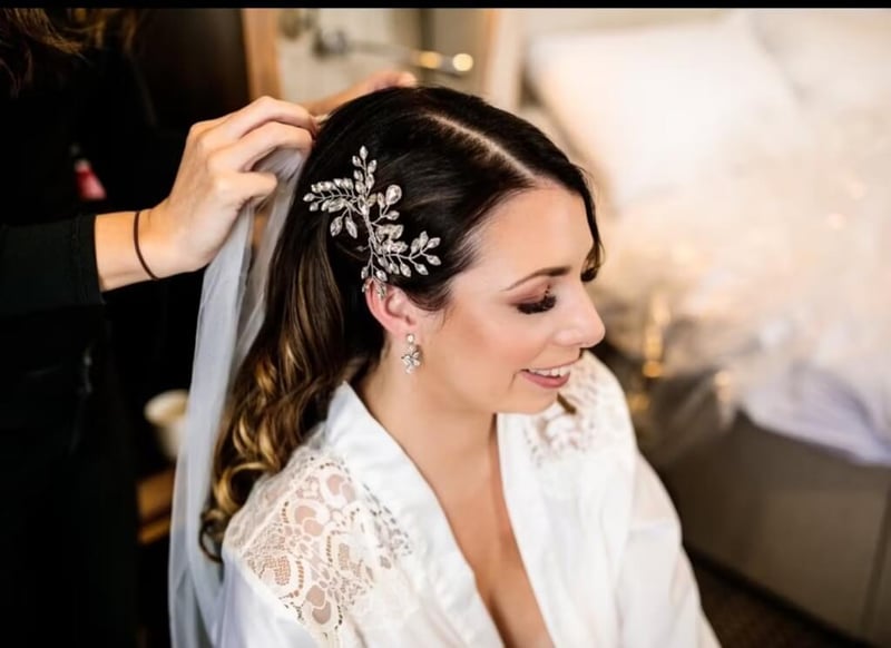 hair stylist putting a veil on a bride with Hollywood waves and diamante clip