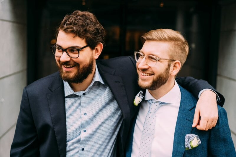 Bräutigam und Trauzeuge lachen und umarmen sich herzlich vor der Feier