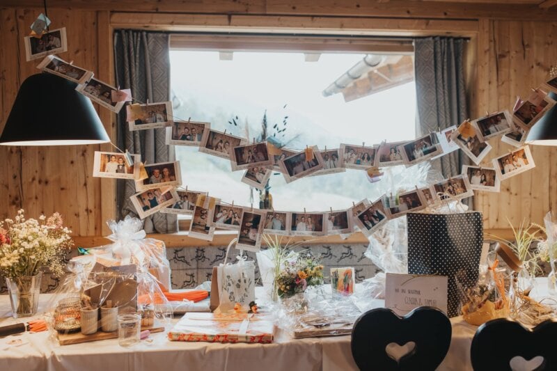 Girlande aus Sofortbildfotos der Hochzeitsgäste über dem Geschenke- und Gästebuchtisch