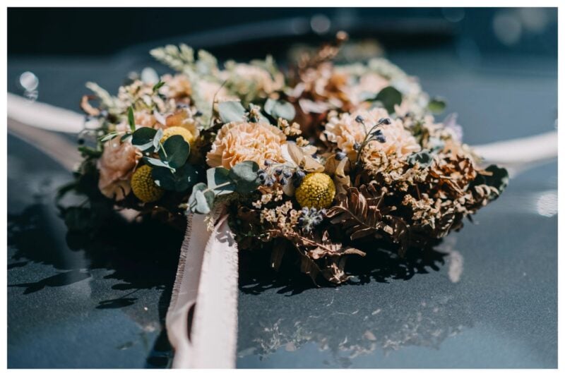 Hochzeitsauto-Deko mit Trockenblumen in Apricot, Senfgelb und Braun als herbstliches Farbkonzept