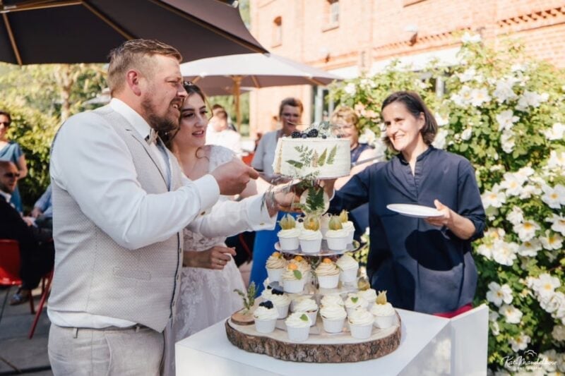 Brautpaar feiert mit Gästen im Freien nach dem Hochzeitsbuffet