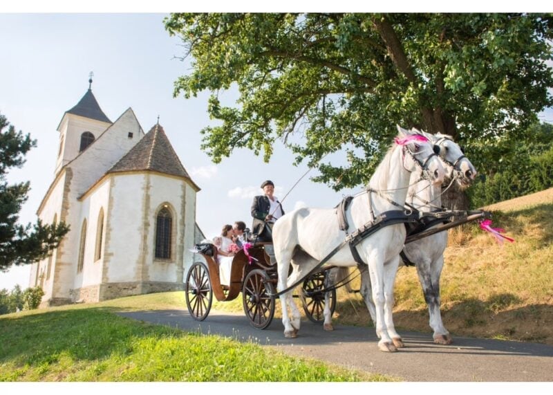 Brautpaar fährt in geliehener Pferdekutsche von der Kirche ab