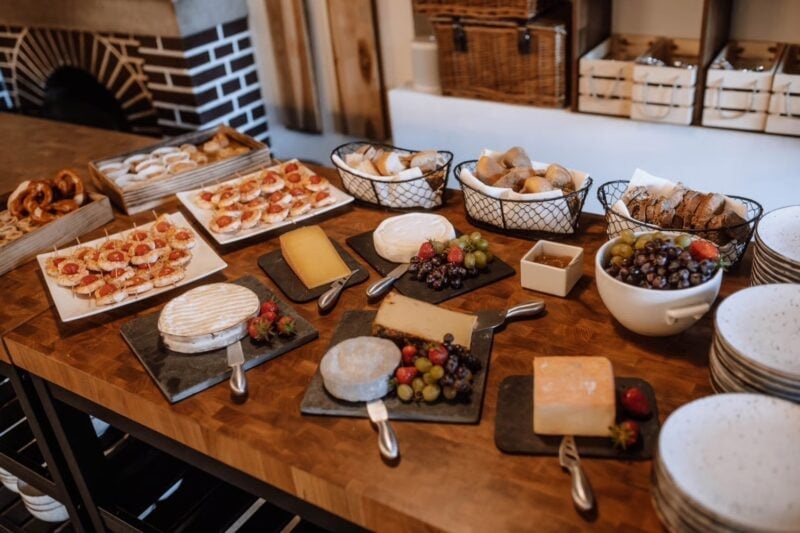 Hochzeitsbuffet mit Brot, Käse und Antipasti auf rustikalem Holztisch