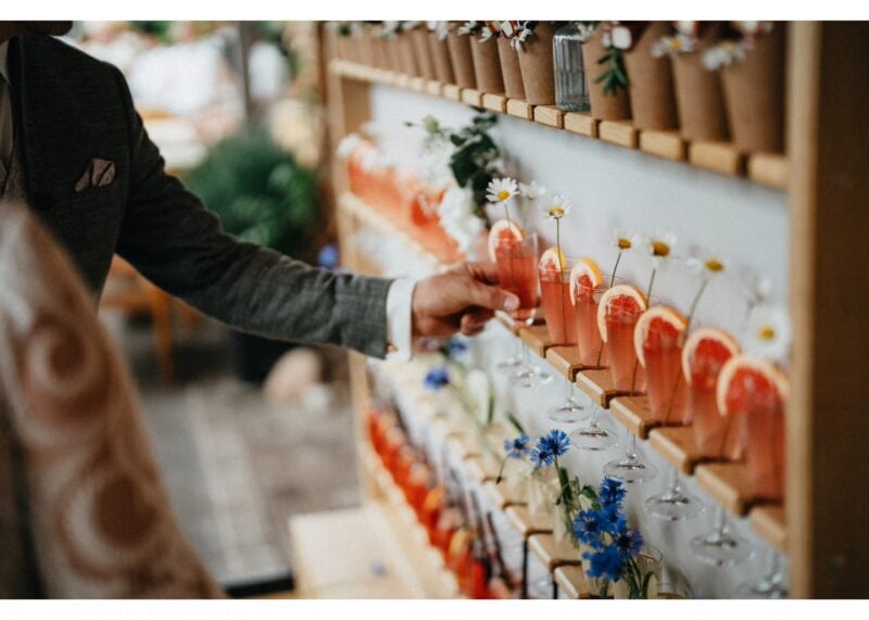Willkommensdrinks in Rosé mit Kornblumen und Gänseblümchen passend zur Hochzeitsfarbpalette