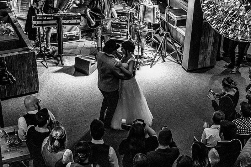Braut tanzt mit ihrem Vater vor Live-Band umringt von Hochzeitsgästen