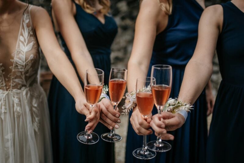 Braut und Brautjungfern stossen beim Sektempfang mit Roséwein an – zentrale Rolle im Hochzeitsprogramm