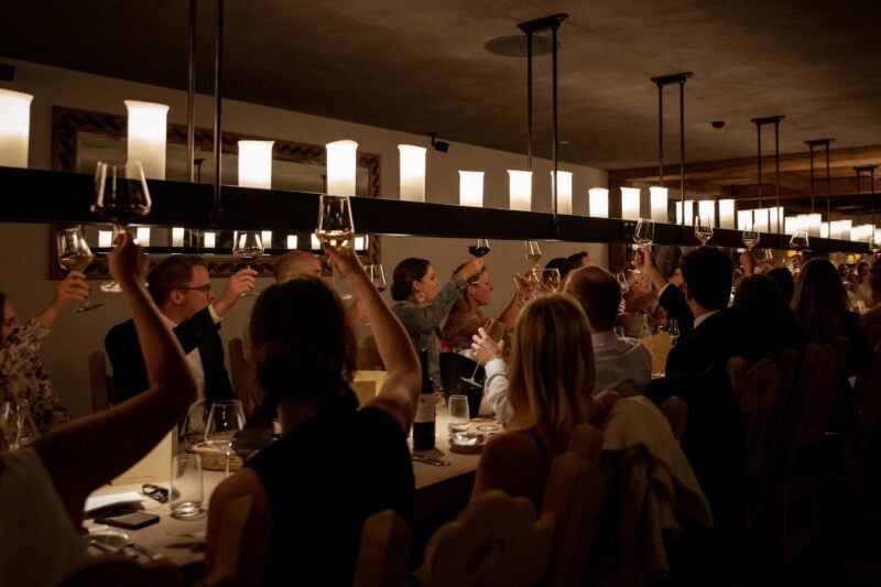 Hochzeitsgäste erheben beim Dinner die Gläser zum Toast – Hochzeitsfeier im Madrisa-Hof