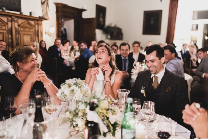 Hochzeitsgäste lachen herzhaft während einer Rede – Vorteile humorvoller Glückwünsche zur Hochzeit