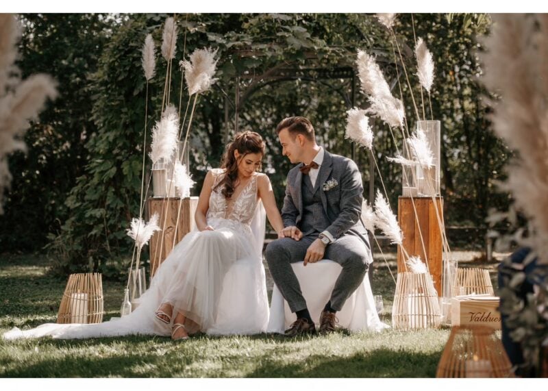Brautpaar sitzt bei der freien Trauung vor Pampasgras-Deko im Garten – Hochzeit im bloomeventhaus