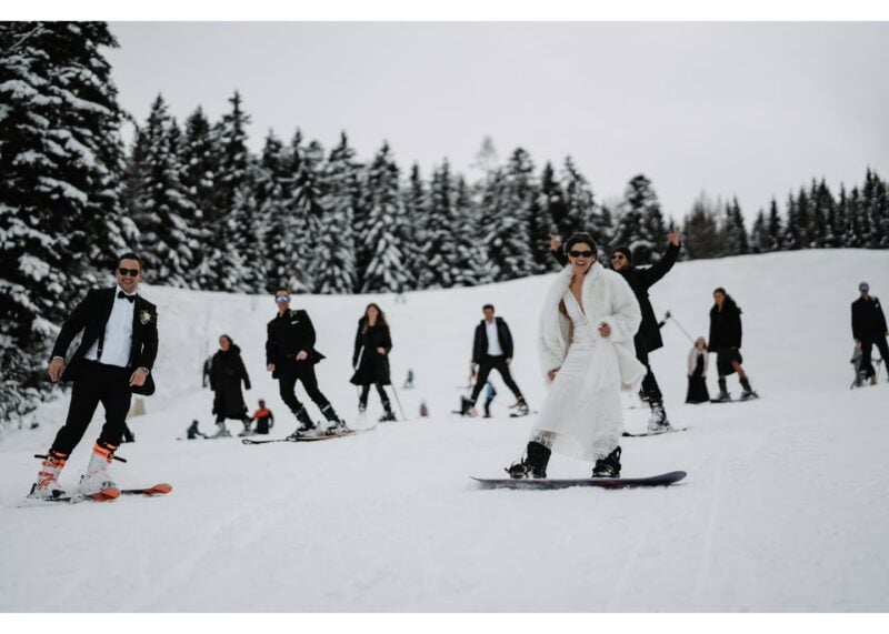 Braut fährt im Hochzeitskleid Snowboard, Bräutigam im Anzug auf Skiern – aussergewöhnliche Unterhaltungsidee je nach Hochzeitsstil