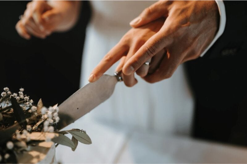 Brautpaar schneidet gemeinsam die Hochzeitstorte an – Hochzeit im Lebenberg Schlosshotel Kitzbühel