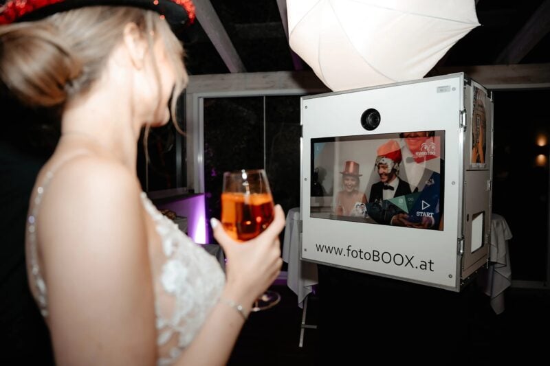 Braut hat Spaß in der Fotobox als lustiges Hochzeitsspiel auf der Feier