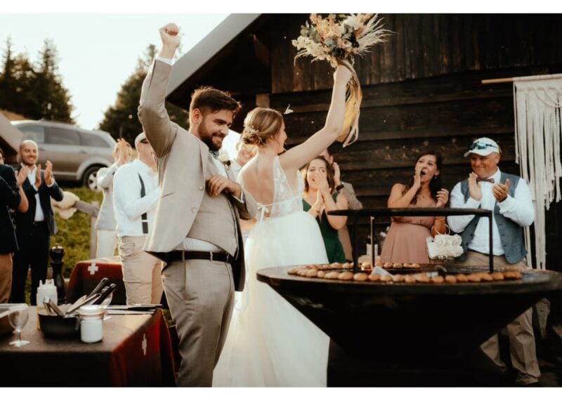 Brautpaar jubelt ausgelassen mit Gästen bei der Hochzeitsfeier – krönender Abschluss der Hochzeitsunterhaltung