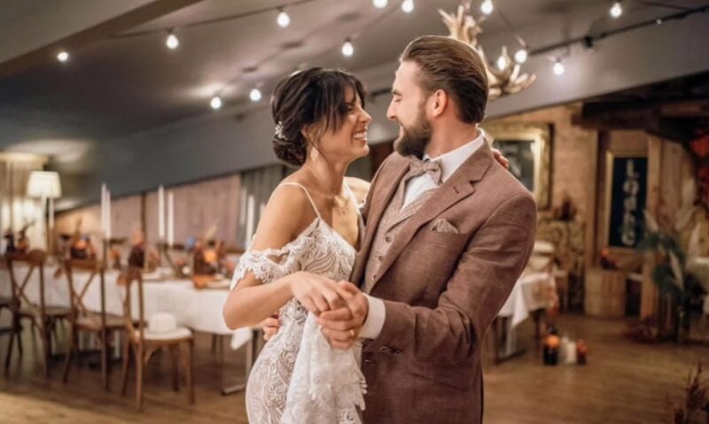 Brautpaar tanzt eng umschlungen beim Hochzeitsempfang im Loube, im Hintergrund festlich gedeckte Tische