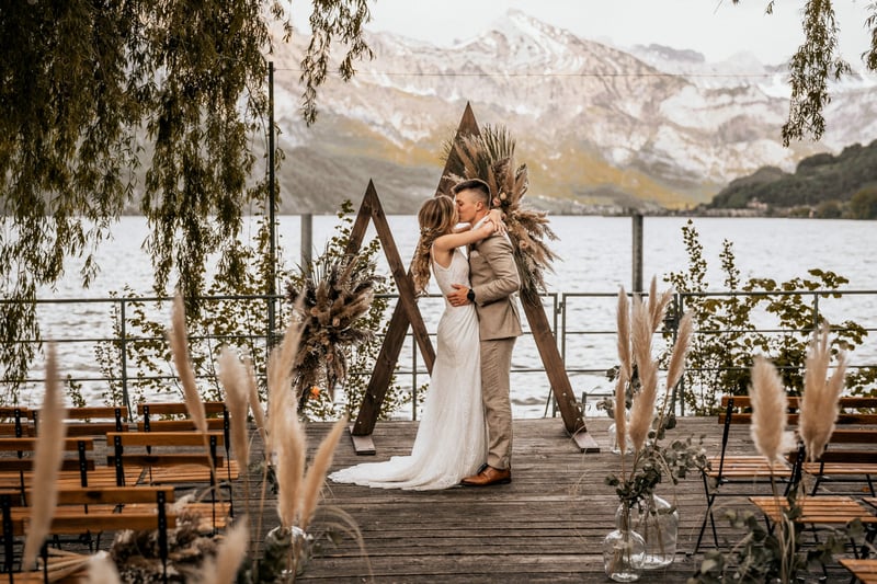 Hochzeitspaar küsst sich vor See