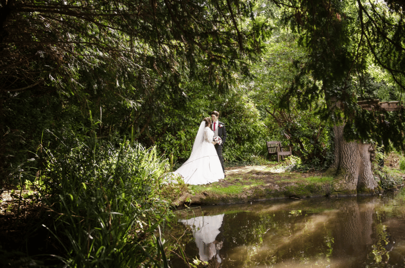 Newly wedded couple taking posed photographs outside the wedding venue