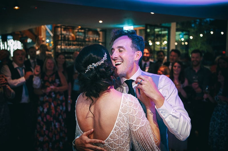 a groom closes his eyes and smiles as he dances with his bride