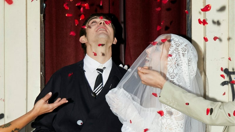 newlyweds looking up at petal confetti being thrown over them