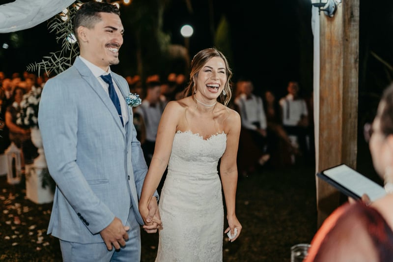 Couple hand in hand laughing together during their wedding ceremony