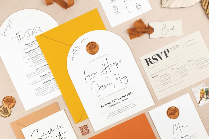 a selection of modern wedding invitations and stationery pieces in a palette of white, rust and yellow.
