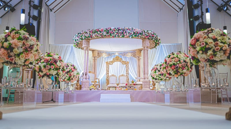 a mandap covered with beautiful flowers and a flower-lined aisle