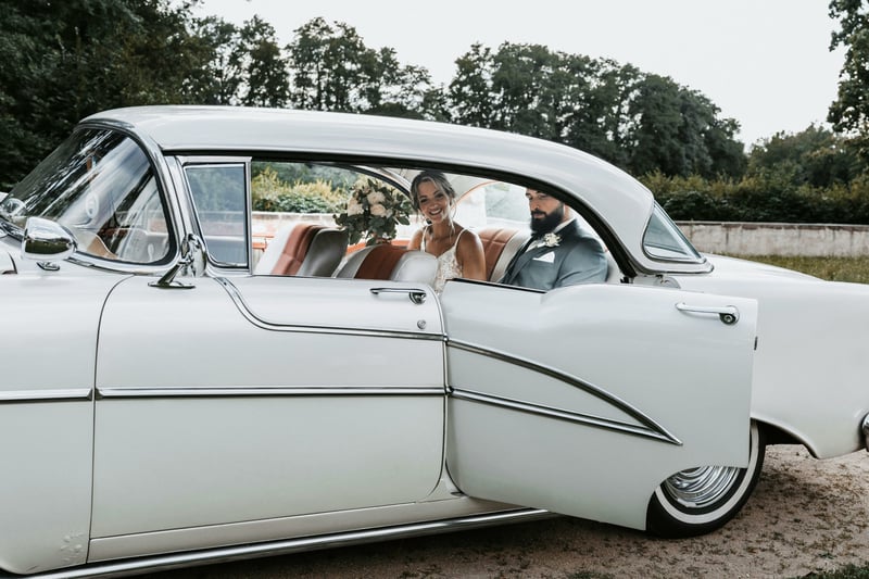 Bride sitting in a vintage wedding car