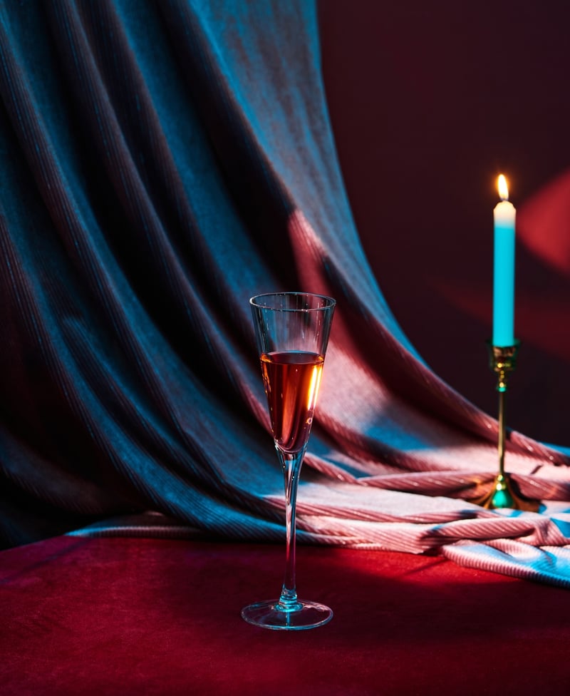 draped wedding backdrop with a glass of champagne and a candle