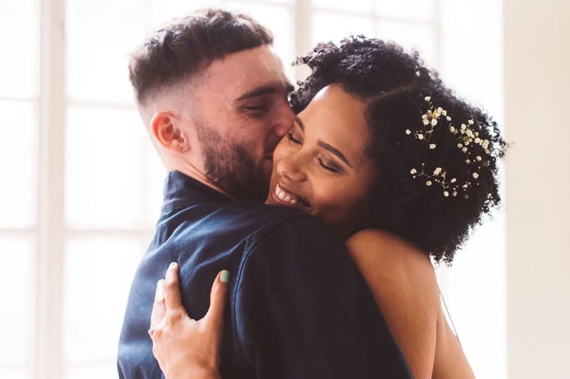 couple cuddling and smiling on their wedding day 
