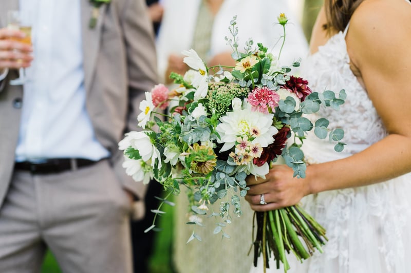 a close-up of a bride's hand-tied bouquet.