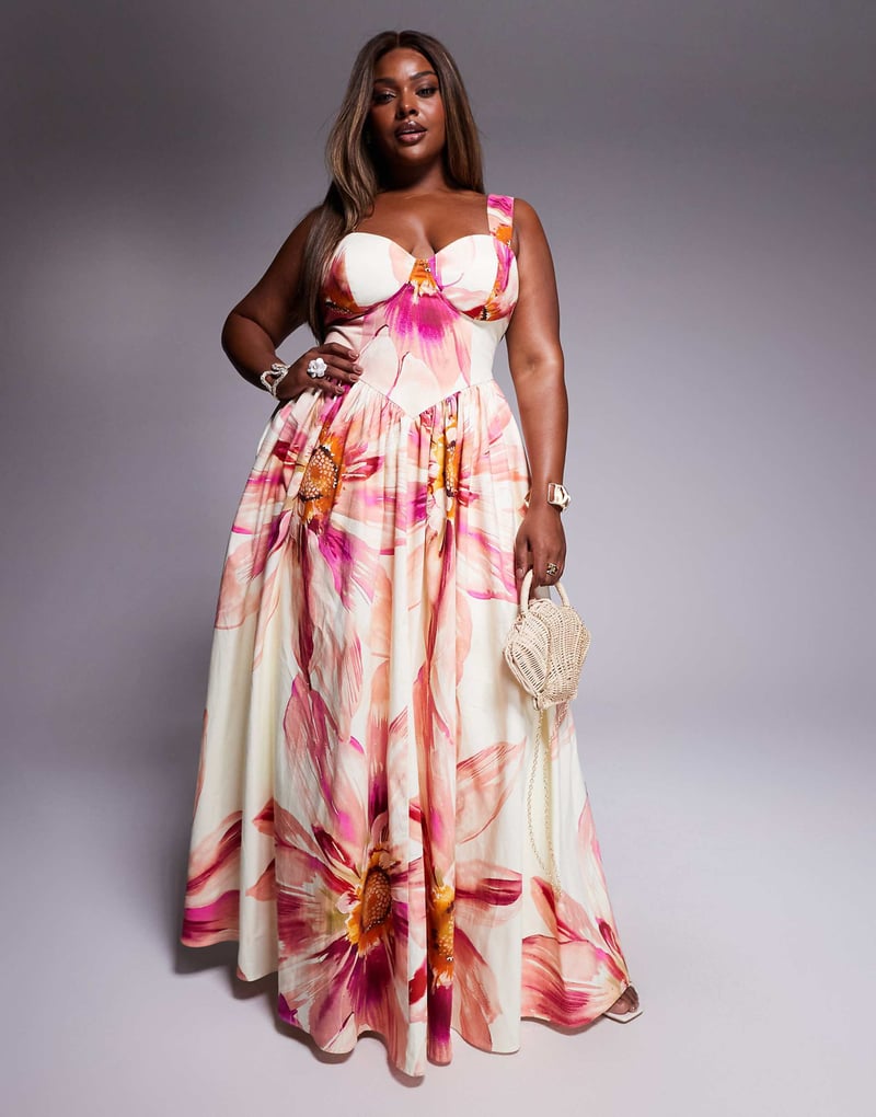 a plus size model wears a floral maxi dress with sweetheart neckline and straps.