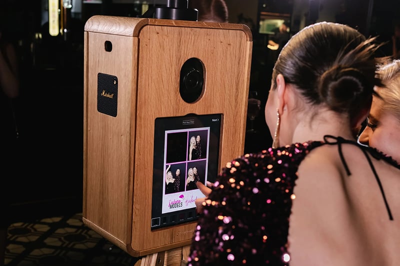 woman touching the screen of a wedding photo booth