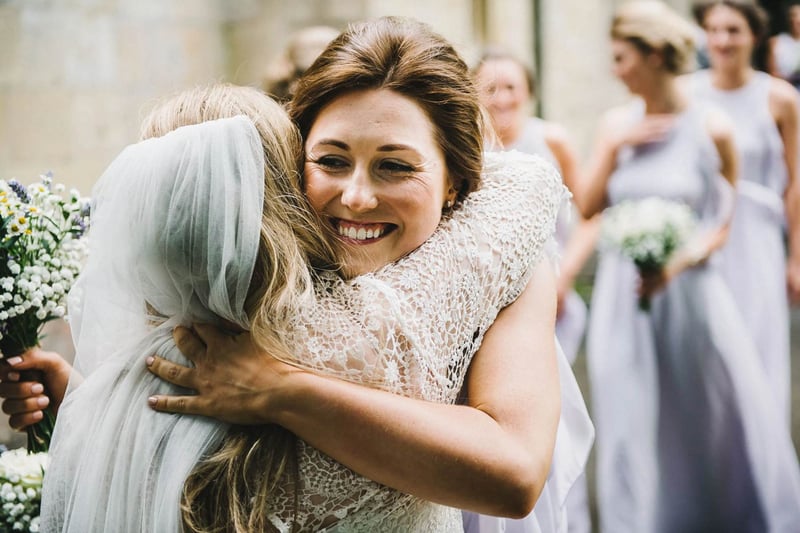 A maid of honour hugging the bride tightly