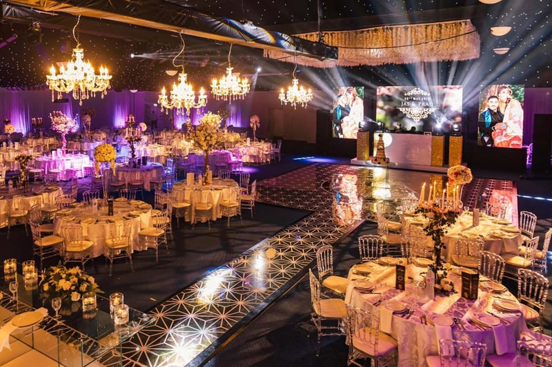 A grand wedding reception in the Centenary Pavilion at Leeds United Football Club, with chandeliers, round tables and a starlit ceiling