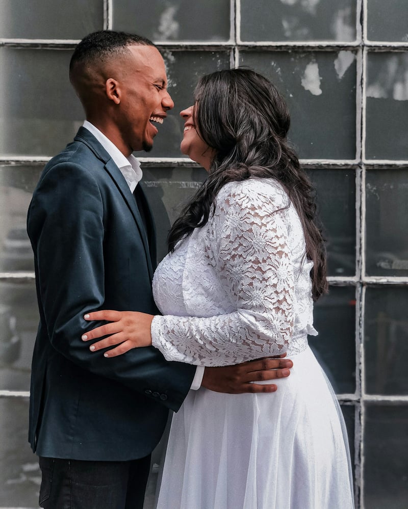 Bride and groom facing each other and laughing after marriage