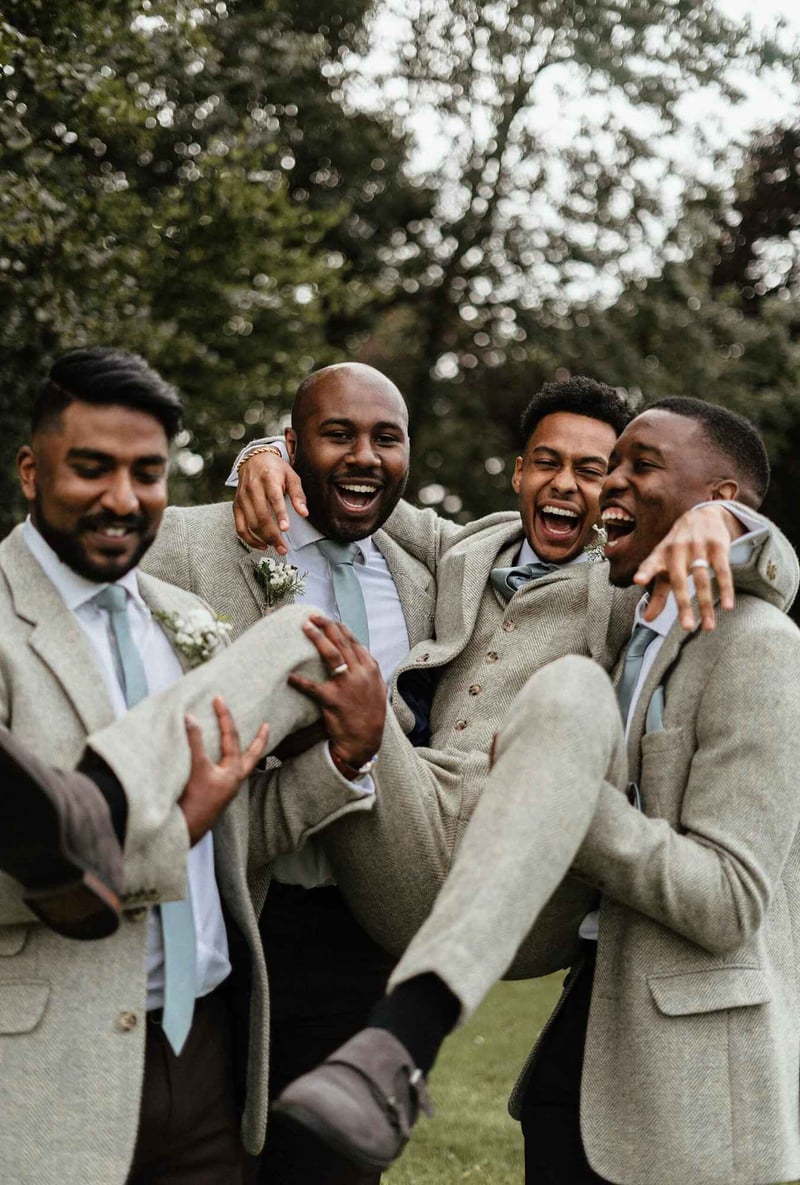 Groom being lifted up by his best man and groomsmen