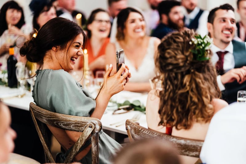 A bridesmaid capturing content on her phone at a wedding