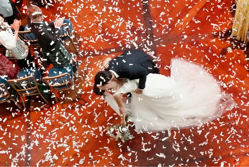 overhead view of a newly wedded couple in a dip, sharing a kiss