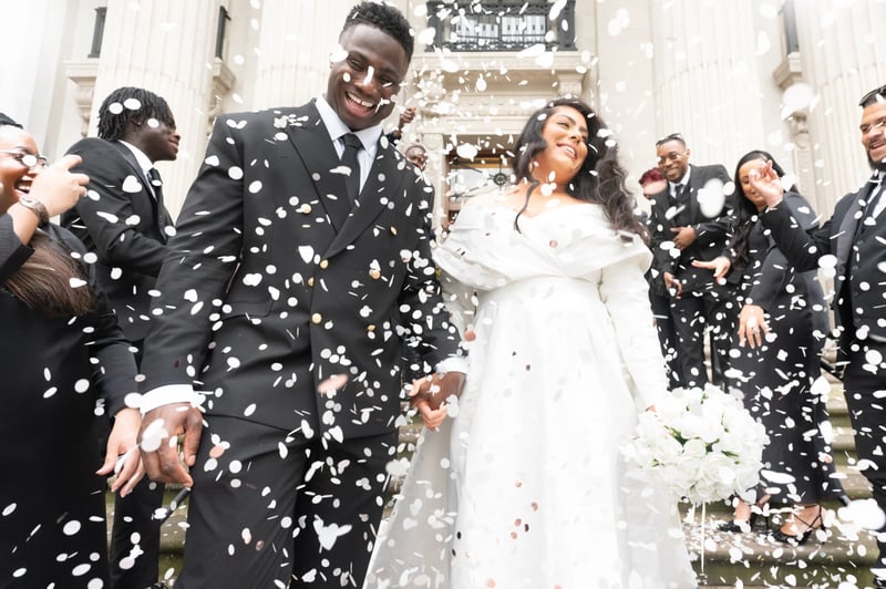 couple leaving their wedding with confetti flying in the air 