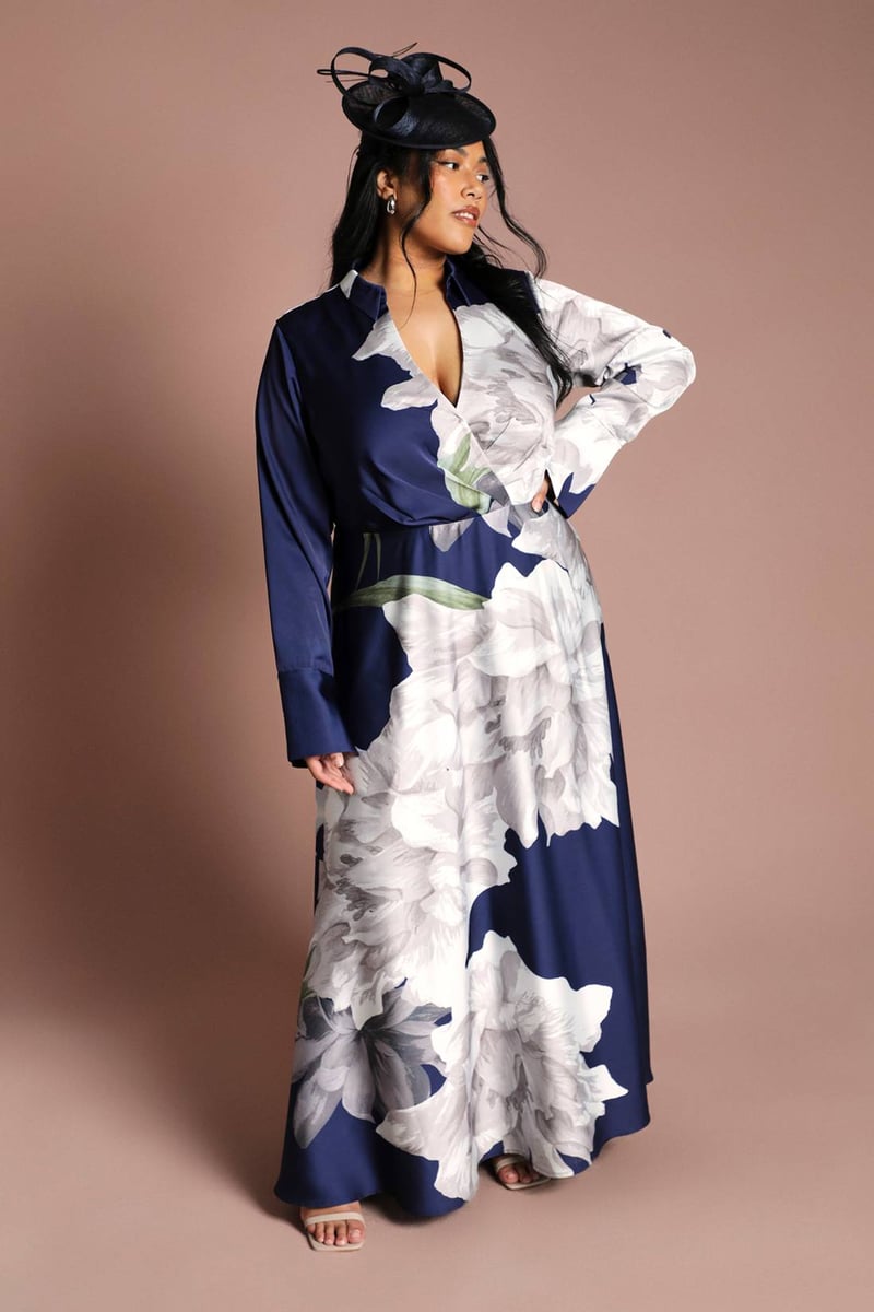 a plus size model wears a long-sleeve satin wrap maxi dress with oversized floral print.