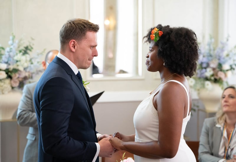 a bride and groom hold hands and look into each other's eyes as they say their vows at their civil ceremony.