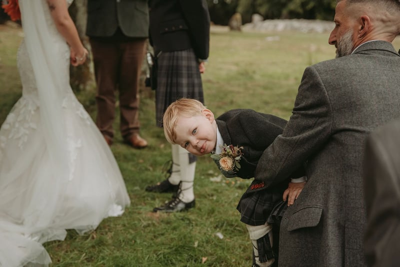 A ring bearer sticking his tongue out